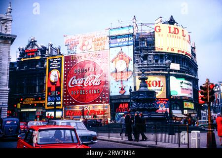 Piccadilly Circus London 1967, with signage advertising Coca Cola, Skol,Guinness and Bulova watches Stock Photo