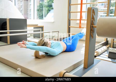 Athletic woman doing crunches lying on special floor for fitness exercises Stock Photo