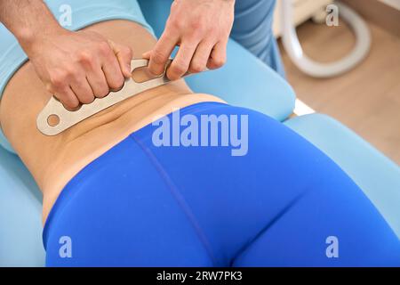 Registered massage therapist using instrument assisted soft tissue mobilization Stock Photo