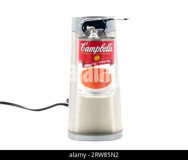 Opening a can of tomato soup with a posh stainless steel electric can opener. Stock Photo