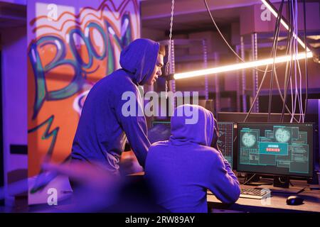 Hackers getting access denied on server while using malware on computer. Unhappy criminals in hoods breaking network system unsuccessfully while doing illegal crime activites Stock Photo