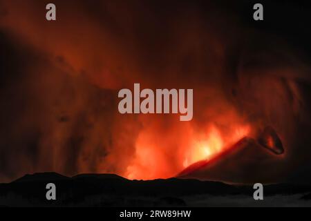Etna during a suggestive eruption at night from the volcano's crater with imaginary faces and shapes created by smoke emissions. August 2023 Stock Photo