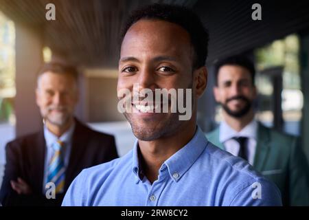 Smiling American black business man in suits looking happy at camera outside office building. Stock Photo