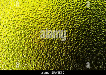 Close-up abstraction of textured green and yellow window glass. Stock Photo