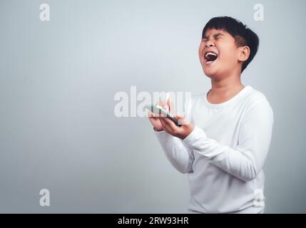 Social media and technology concepts. Boy's hands holding a smartphone and stylus pencil to use multimedia and social media to communicate. Stock Photo