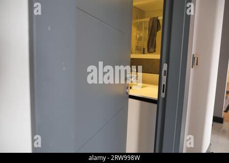 gray bathroom door slightly open . Stock Photo