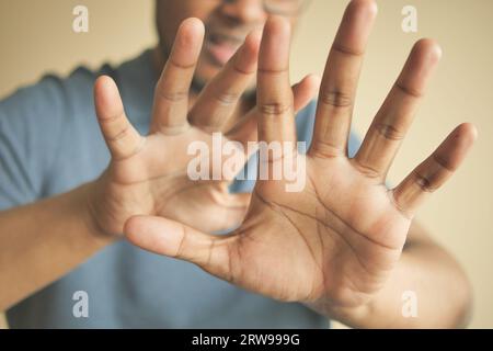 young man show stop sigh isolated in black  Stock Photo