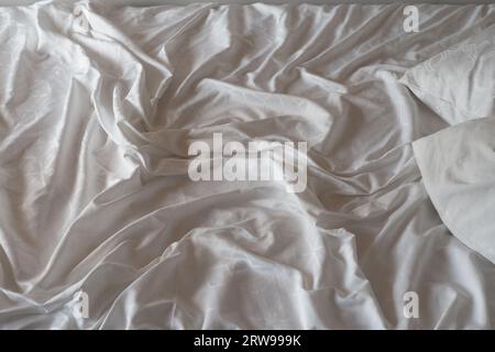 white messy bed in early morning , messy bed after waking up  Stock Photo