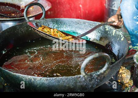 deep frying of big chili at mustered oil at street shop or Mirchi badda local dishes of india at street Stock Photo