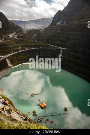 The old Ertsberg mine that is now flooded with water, the Grasberg open pit mine is in the background Stock Photo