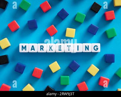 Business marketing concept. Colorful cubes on blue background with the word marketing. Stock Photo