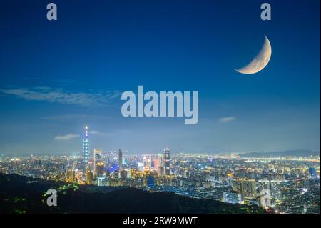 Urban splendor at night: Watch the dynamic clouds and moon above the cityscape. View of Taipei city from the Four Beasts Mountain Trail, Taiwan Stock Photo