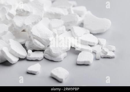 Calcium chloride (CaCl2) flakes. Common applications include brine for refrigeration plants, ice and dust control on roads, and desiccation Stock Photo