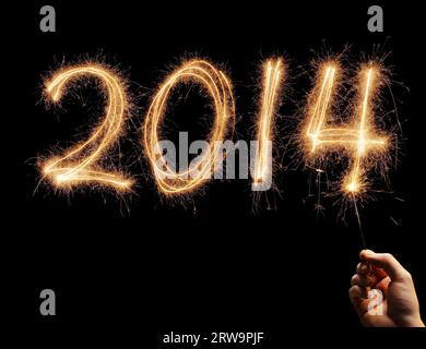 Man writing number 2014 with a sparkler in his hand Stock Photo