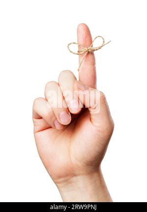 A Piece of string tied around man's index finger. Short depth of field, the sharpness is in the knot Stock Photo