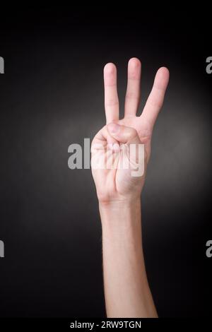 Human hand showing number three. Neutral background