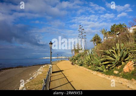 Costa del Sol promenade along the Mediterranean Sea from Marbella to Puerto Banus (visible on the horizon) in Spain, Malaga province, Andalucia Stock Photo