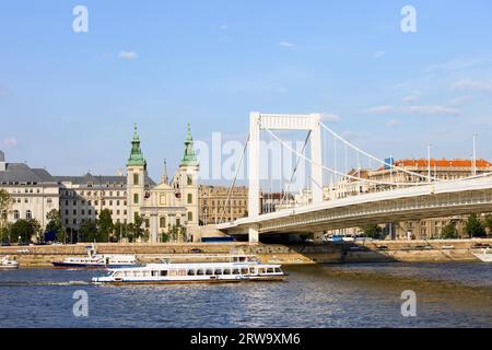 Cityscape of Budapest with Inner City Parish Church, Elizabeth Bridge and passenger boats on the Danube river in Hungary Stock Photo