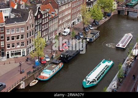 City of Amsterdam in Holland, Netherlands, tour boats on a canal and traditional houses along Prinsengracht street, view from above Stock Photo