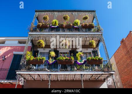 Flowers in baskets hang off shutter doors during Mardi Gras in New Orleans, Louisiana, USA Stock Photo