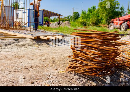 Pile of rusty bent quadratic reinforcement bars placed at the construction site. Stock Photo