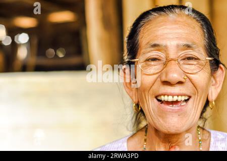 Damak, Nepal, circa May 2012: Native woman with glasses and golden piercing in her nose in Damak, Nepal. Documentary editorial Stock Photo