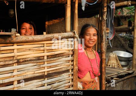 Damak, Nepal, circa May 2012: Two native women smile to photocamera from their house at Nepali refugee camp in Damak, Nepal. Documentary editorial Stock Photo