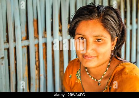 Damak, Nepal, circa May 2012: Young black-haired woman with piercing in her nose wears orange dress at Nepali refugee camp in Damak, Nepal. Stock Photo