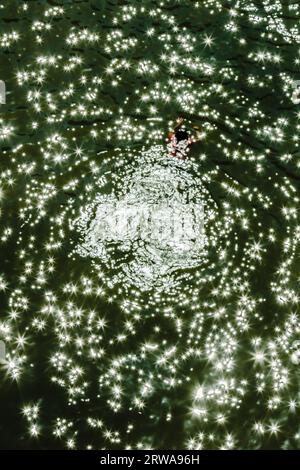 Elevated view of a person swimming in the Russian River with specular highlights Stock Photo