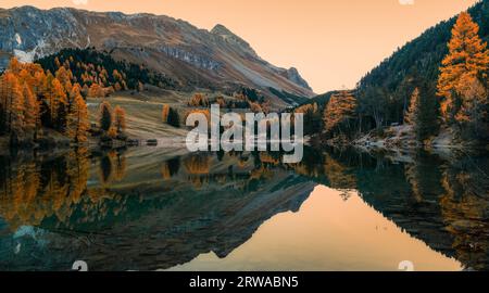 calm mountain lake with reflections of autumn colours in the heart of the Swiss Alps Stock Photo