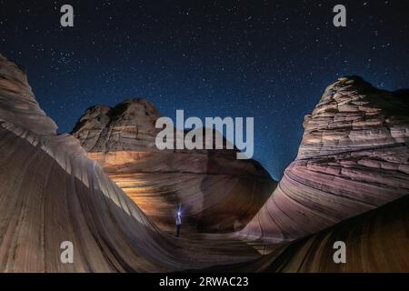 A solitary hiker at the Wave, Arizona, before dawn Stock Photo