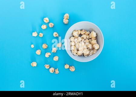 Popcorn in bowl isolated on blue background, after some edits. Stock Photo