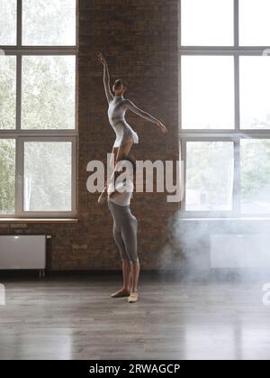 Two athletic modern ballet dancers posing against studio background Stock Photo