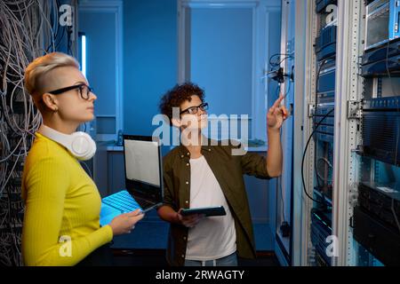 Serious technicians working together with network hardware Stock Photo