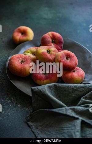Close-up of a bowl of flat peaches Stock Photo