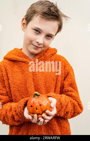 Portrait of a smiling boy holding a ceramic jack-o-lantern ornament Stock Photo