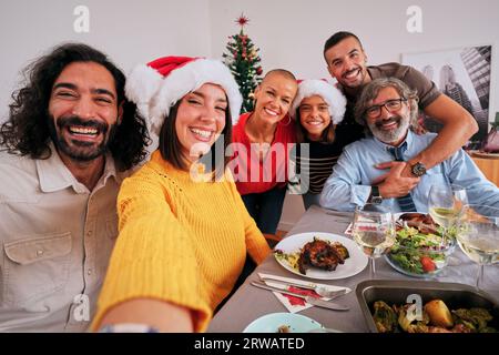 Mobile selfie of smiling Caucasian family looking at camera and happy celebrating Christmas vacation Stock Photo