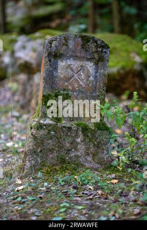 A stone marker with the mining symbol of hammer and pick in the area of "Solvayovy lomy" open air mining museum, Czechia. Stock Photo