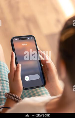 Smartphone in child hands with Incoming mother call on a screen. Stock Photo