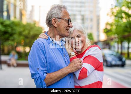 Portrait of a happy senior couple embracing in the city Stock Photo