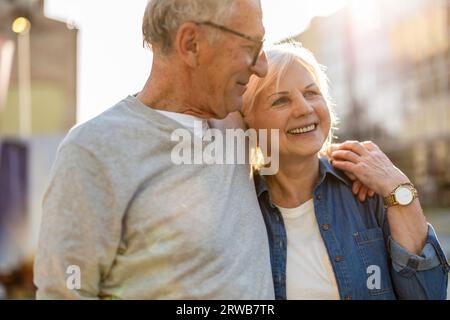 Portrait of a happy senior couple embracing in the city Stock Photo
