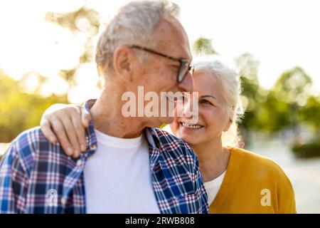 Portrait of happy senior couple standing in city street on a sunny day Stock Photo