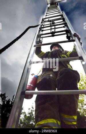 DFD1 chimmneyfire 44 NorthShoreDr06-04-2023  FF Bailey Oliverira climbing 35 foot ladder to Capt Costa Stock Photo