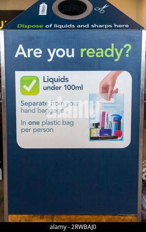 Bin for waste liquid, liquids, sharp items and sharps, displaying rules on what's permitted through hand luggage and security. Gatwick airport. UK. (135) Stock Photo