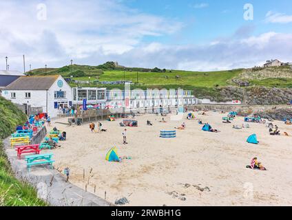Holidaymakers and day trippers on the sandy Porthgwidden beach at St Ives, Cornwall, with the tide of the Atlantic Ocean out on a cloudy and sunny day. Stock Photo