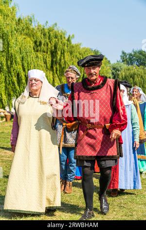 Medieval band of minstrels, Rough Musicke, in period costume dancing on the green at a summertime event reenactment at Sandwich town in Kent. Stock Photo
