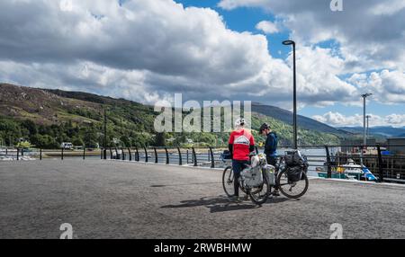 Two cyclists on the quayside in Ullapool, Scottish Highlands Stock Photo