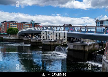Belfast County Antrim Northern Ireland June 03 2017 - People walking over the curved Lagan Weir foot bridge across the Lagan Weir in Belfast Stock Photo