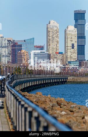 The Liberty State Park walkway, spanning the Hudson Riverfront from Black Tom Island to the CRRNJ Terminal, offers a view of the Jersey City skyline. Stock Photo