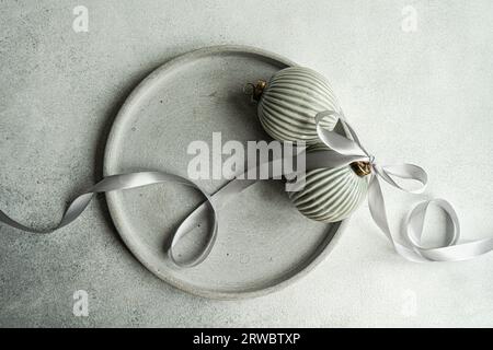 Top view of balls decorated with satin ribbon as symbol of Christmas time placed on gray surface Stock Photo